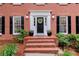 Close up of a classic white-trimmed door, brick steps, and decorative plants at 1582 E Bank Dr, Marietta, GA 30068