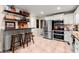 A kitchen with stainless steel appliances, white cabinets, tile floor and wooden stools at the breakfast bar at 1582 E Bank Dr, Marietta, GA 30068