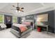 The primary bedroom features a tray ceiling, fan, sitting area and windows overlooking the yard at 1582 E Bank Dr, Marietta, GA 30068