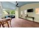 A screened porch with wood floors, a fan, furnishings, views of the wooded yard and a TV at 1582 E Bank Dr, Marietta, GA 30068