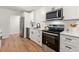 Modern kitchen with stainless steel appliances, white cabinets, and sleek black hardware at 2011 W Starmount Way, Decatur, GA 30032