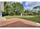 Spacious backyard with a brick patio, lush green lawn, mature trees, and outdoor drying rack for a relaxing retreat at 2944 Berry Rd, Loganville, GA 30052