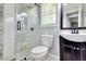 Well-lit bathroom showcasing a glass-enclosed shower, dark vanity, and tiled flooring at 2944 Berry Rd, Loganville, GA 30052