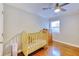 Bright Bedroom featuring hardwood floors, a crib, and a window providing ample natural light at 2944 Berry Rd, Loganville, GA 30052