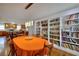 Open dining room with bookshelves, an oval table with orange tablecloth, and pendant lighting, adjacent to kitchen at 2944 Berry Rd, Loganville, GA 30052