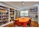 Dining room with custom bookshelves, a large oval table with orange tablecloth, and pendant lighting at 2944 Berry Rd, Loganville, GA 30052