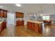 Bright kitchen with wood cabinets, granite countertops, stainless steel appliances, and an open flow to other rooms at 2944 Berry Rd, Loganville, GA 30052