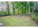 The grassy backyard features mature trees and lush greenery, offering a private and tranquil outdoor space at 5795 Deerfield Trl, Atlanta, GA 30349