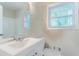 Bathroom featuring white sink and cabinet, toilet and window is captured in this image at 5795 Deerfield Trl, Atlanta, GA 30349