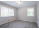 Bedroom featuring neutral carpet and gray walls has two windows bringing in natural light at 5795 Deerfield Trl, Atlanta, GA 30349