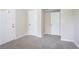 Spacious bedroom featuring fresh paint, new carpet, and multiple doors for easy access at 5795 Deerfield Trl, Atlanta, GA 30349