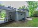 Side view of the gray brick home featuring a covered parking area, a small back patio, and a new HVAC unit at 5795 Deerfield Trl, Atlanta, GA 30349