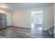 Open kitchen area featuring stainless steel refrigerator, white cabinetry, and gray wood flooring at 5795 Deerfield Trl, Atlanta, GA 30349