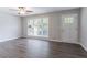 Bright, open living area with hardwood floors, fan and a large window at 5795 Deerfield Trl, Atlanta, GA 30349