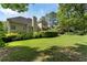 Sprawling backyard with lush lawn, mature trees, and manicured hedges surrounding the property at 1605 Little Lisa Ln, Snellville, GA 30078