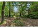 Private wooded backyard with an outdoor fire pit and a serene view of the home and surrounding trees at 1605 Little Lisa Ln, Snellville, GA 30078