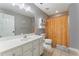 Well-lit bathroom featuring a vanity, mirror, toilet and shower with orange curtain at 1605 Little Lisa Ln, Snellville, GA 30078
