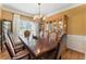 Bright dining room with a large wooden table set under a chandelier next to the window at 1605 Little Lisa Ln, Snellville, GA 30078