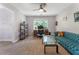 Bright living room with plush blue couch, large window, desk and ceiling fan at 1605 Little Lisa Ln, Snellville, GA 30078