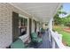 Covered front porch with seating and a gray deck overlooking the landscaped yard at 185 Pamela Nw St, Marietta, GA 30064