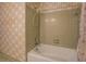 Retro bathroom features tile shower and tub with bright floral wallpaper at 1850 Francis Sw Rd, Conyers, GA 30094