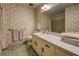 This bathroom has a shower-over-tub and vanity with sink, plus wallpaper with floral pattern at 1850 Francis Sw Rd, Conyers, GA 30094