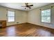 An airy bedroom features hardwood floors, two windows, and a ceiling fan for added comfort at 1850 Francis Sw Rd, Conyers, GA 30094