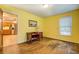 Bedroom features yellow walls, wood floors, and leads to a kitchen area at 1850 Francis Sw Rd, Conyers, GA 30094