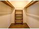 This is a walk-in closet with wooden shelves and hardwood floor in neutral color at 1850 Francis Sw Rd, Conyers, GA 30094