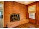 Close up of a brick fireplace in a room with hardwood floors and wood-paneled walls at 1850 Francis Sw Rd, Conyers, GA 30094