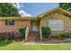 Charming home exterior featuring a mix of brick and stone, complemented by green shrubs and a welcoming front entrance at 1850 Francis Sw Rd, Conyers, GA 30094