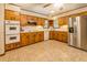 A traditional kitchen features wood cabinets, tile floors, and stainless steel appliances at 1850 Francis Sw Rd, Conyers, GA 30094