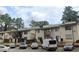 Exterior view of a multi-unit residential building featuring balconies and ample parking at 3796 Kensingwood Trce, Decatur, GA 30032