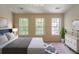 Inviting bedroom with three large windows providing ample natural light and a decorative rug at 3990 Howell Park Rd, Duluth, GA 30096