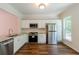 Modern kitchen with stainless steel appliances, granite countertops, and white cabinetry at 3990 Howell Park Rd, Duluth, GA 30096