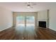 Hardwood-floored living room with fireplace, ceiling fan, and sliding glass doors to a deck at 3990 Howell Park Rd, Duluth, GA 30096