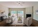 Bright living room featuring a fireplace, hardwood floors, and sliding glass doors to a deck at 3990 Howell Park Rd, Duluth, GA 30096