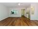 Spacious living room with hardwood floors, a view of the kitchen, and access to the staircase at 3990 Howell Park Rd, Duluth, GA 30096