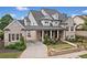 Charming exterior view of a brick home showcasing a covered porch, manicured shrubs, and a driveway at 487 Carmichael Cir, Canton, GA 30115