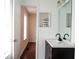 Bright bathroom featuring double sinks with dark cabinetry, granite countertops, and an open door leading to the toilet at 5624 Stonington Trace Pkwy, Stone Mountain, GA 30087