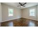 Empty bedroom features hardwood floors, a ceiling fan, and bright windows at 2509 Browns Mill Se Rd, Atlanta, GA 30354