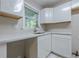 View of kitchen featuring white cabinets, stainless steel sink, and marble countertop with a window at 2509 Browns Mill Se Rd, Atlanta, GA 30354