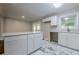 Updated kitchen with marble floors, white cabinets, countertops and bar island overlooking a sunlit doorway at 2509 Browns Mill Se Rd, Atlanta, GA 30354