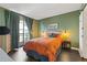 Bright bedroom featuring stylish decor, wood floors, balcony access, and a comfortable queen-sized bed at 3481 Lakeside #901 Ne Dr, Atlanta, GA 30326