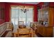 Elegant dining room with rich red walls, hardwood floors, and a large window with sheer drapes at 3606 Packhorse Run, Marietta, GA 30066