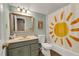 Neutral bathroom with a sun-themed shower curtain, single sink vanity, and framed mirror at 4112 Willow Sw Walk, Lilburn, GA 30047