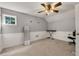 Well-lit bedroom featuring soft gray walls, wainscoting, ceiling fan, and a full-length mirror and space for a keyboard at 4112 Willow Sw Walk, Lilburn, GA 30047