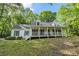 Charming two-story home with a large front porch and well-manicured lawn surrounded by mature trees at 4112 Willow Sw Walk, Lilburn, GA 30047