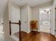 Upstairs hallway featuring hardwood floors, white doors, and a glimpse into a bedroom with a ceiling fan at 4112 Willow Sw Walk, Lilburn, GA 30047