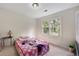 Bright bedroom with a window overlooking the yard and a colorful blanket on the bed at 4994 Willow Creek Dr, Woodstock, GA 30188